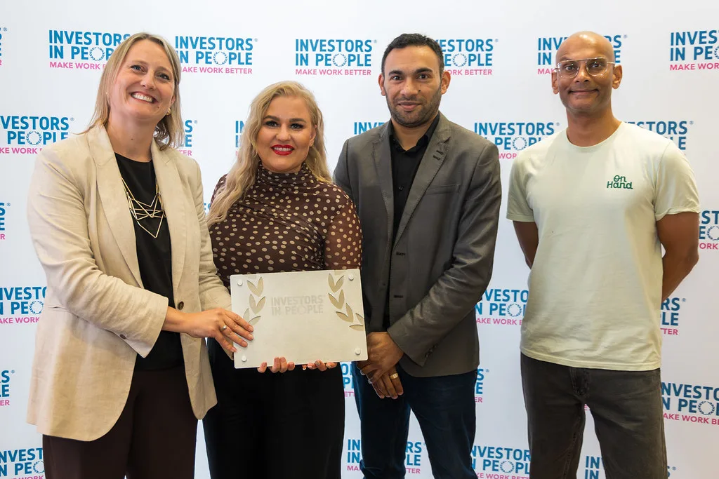 Colleagues holding an Investors in People accreditation plaque